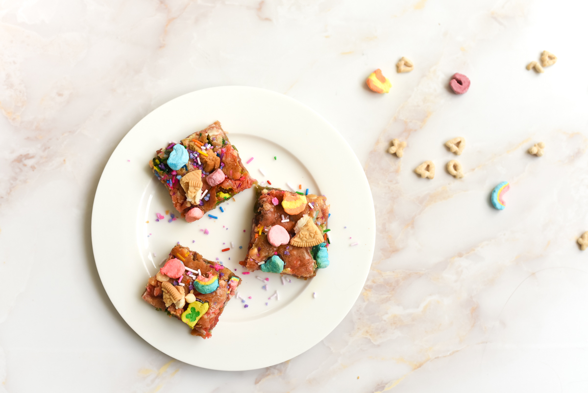 assiette de décadents blondies de licorne avec des décorations de bonbons et biscuits sucrés, par wooloo